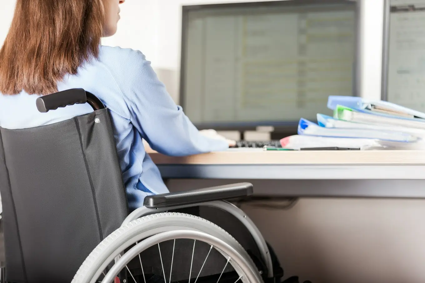 kobieta na wózku inwalidzkim pracująca przed komputerem